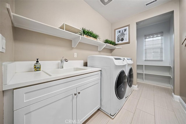 laundry room with cabinets, independent washer and dryer, and sink