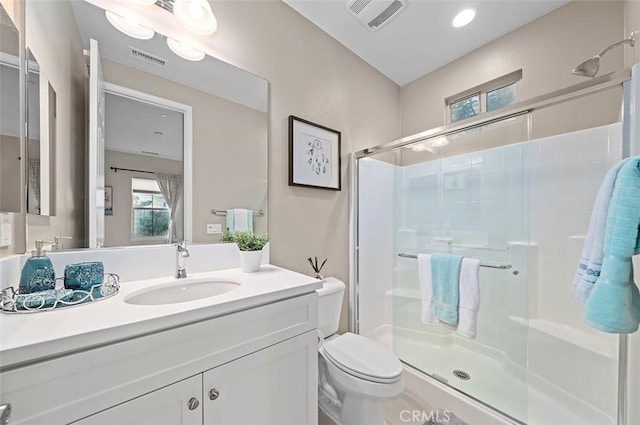 bathroom featuring an enclosed shower, vanity, and toilet