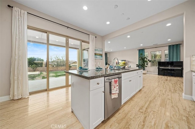 kitchen with sink, white cabinets, stainless steel dishwasher, a center island with sink, and light hardwood / wood-style flooring