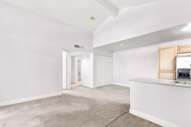 carpeted empty room featuring beamed ceiling and high vaulted ceiling