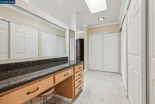 bathroom with ornamental molding and a skylight