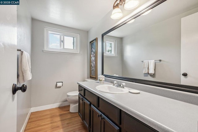 bathroom with vanity, wood-type flooring, a wealth of natural light, and toilet