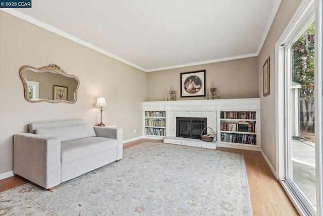 living room with wood-type flooring, ornamental molding, and a premium fireplace