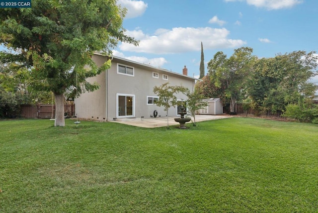 rear view of house featuring a shed, a lawn, and a patio