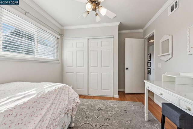 bedroom with crown molding, ceiling fan, a closet, and light hardwood / wood-style flooring