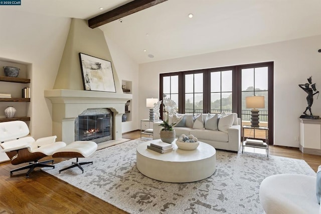 living room with a fireplace, high vaulted ceiling, beam ceiling, and hardwood / wood-style floors