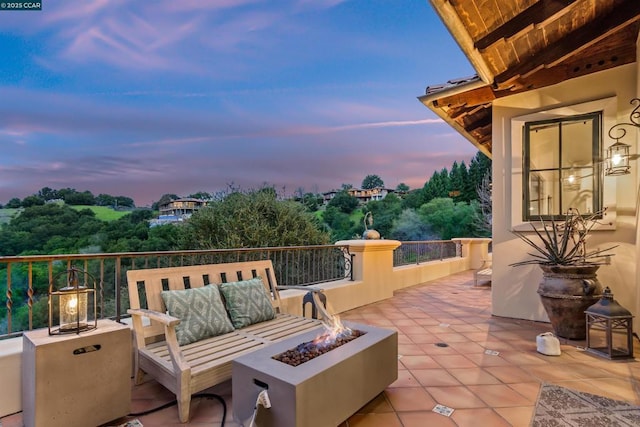 patio terrace at dusk featuring an outdoor fire pit