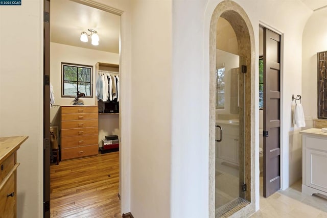 bathroom featuring hardwood / wood-style flooring, vanity, toilet, and a shower with shower door