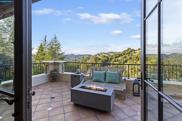 balcony featuring a mountain view and an outdoor living space with a fire pit