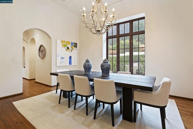 dining room featuring hardwood / wood-style flooring and a towering ceiling