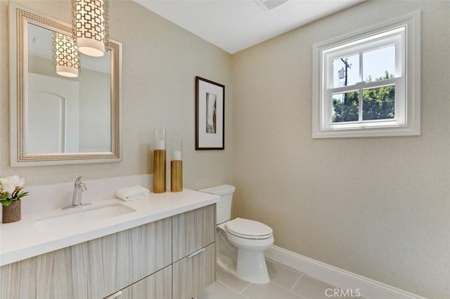 bathroom with vanity, tile patterned flooring, and toilet