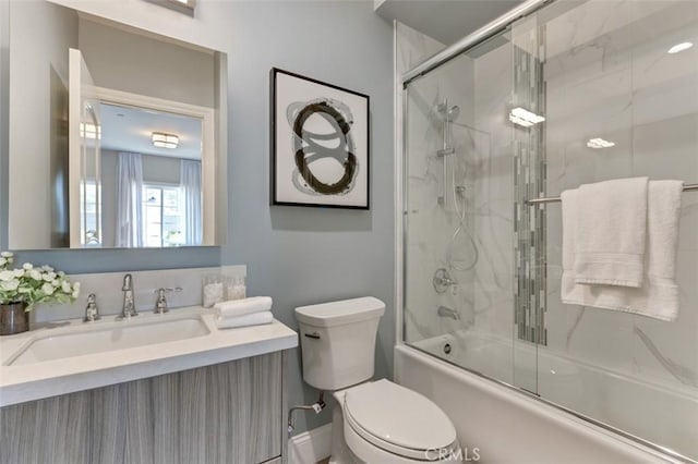 full bathroom with vanity, toilet, and combined bath / shower with glass door