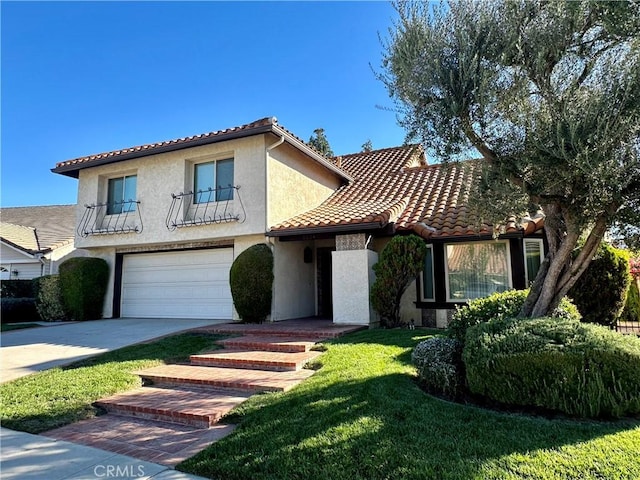 mediterranean / spanish house with a garage, concrete driveway, a tile roof, a front lawn, and stucco siding