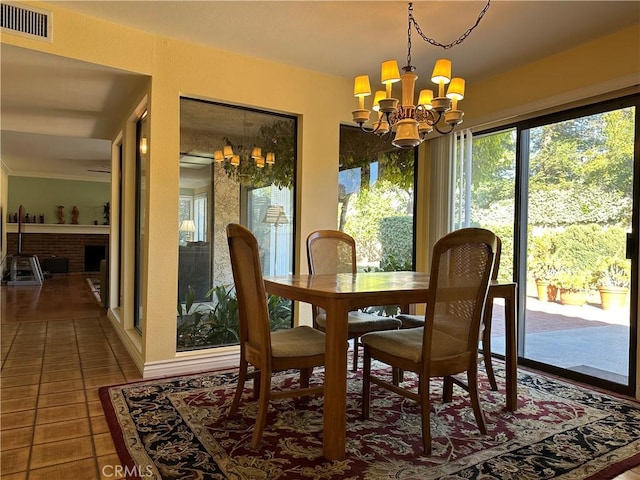 tiled dining space with visible vents and a notable chandelier