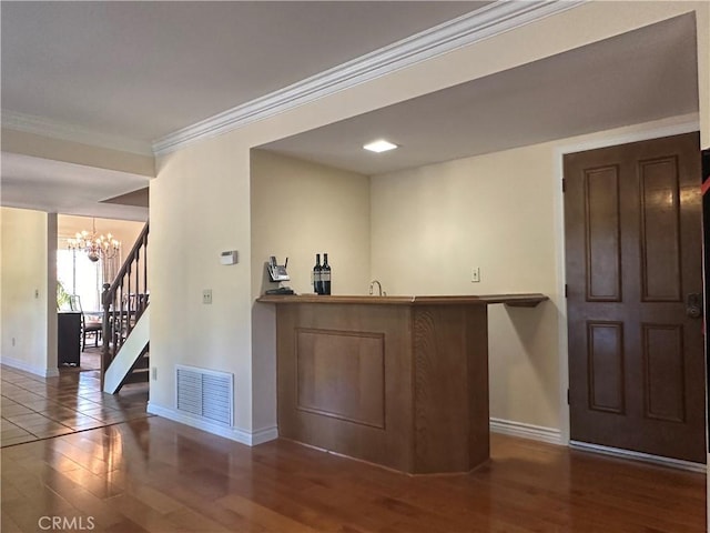 bar featuring visible vents, crown molding, stairway, and wood finished floors