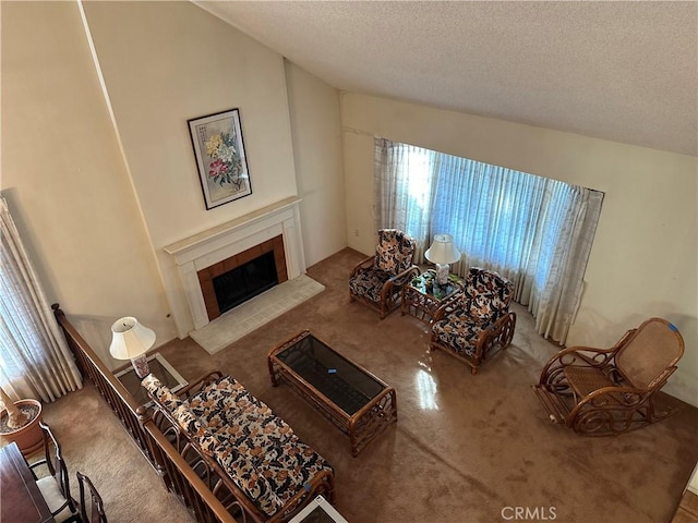 living area with a textured ceiling, a tiled fireplace, carpet flooring, and lofted ceiling