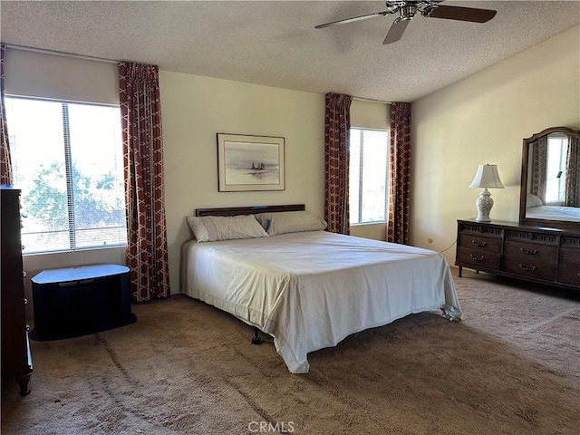 bedroom featuring carpet, ceiling fan, and a textured ceiling