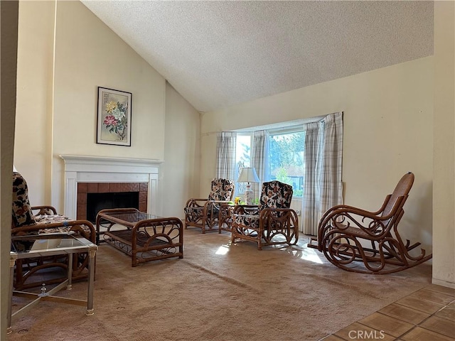 sitting room featuring carpet, high vaulted ceiling, a textured ceiling, and a tile fireplace