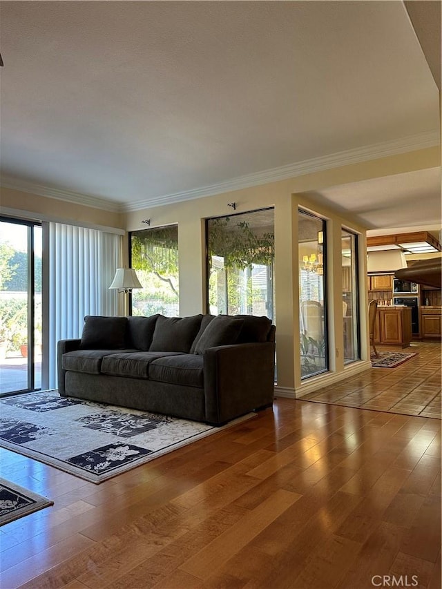 living area with crown molding and wood finished floors