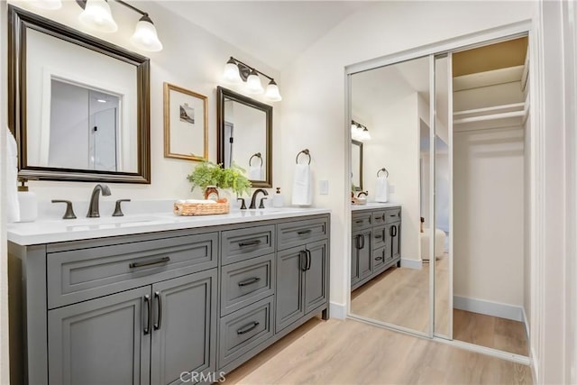 bathroom featuring vaulted ceiling, vanity, and hardwood / wood-style floors