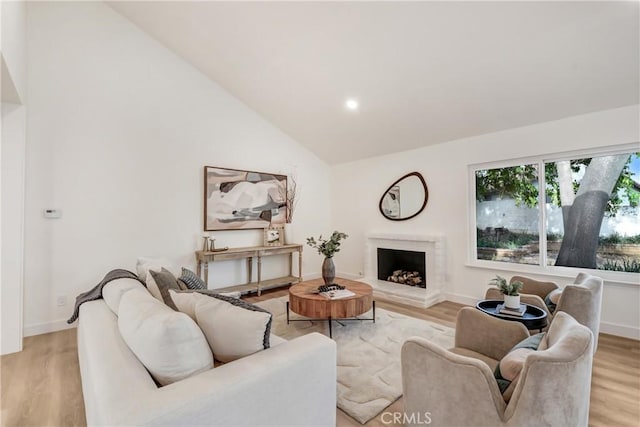 living room featuring light hardwood / wood-style flooring and vaulted ceiling