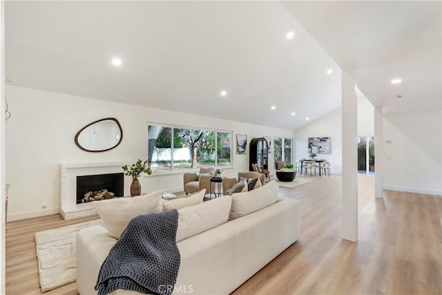 living room featuring lofted ceiling and light hardwood / wood-style flooring