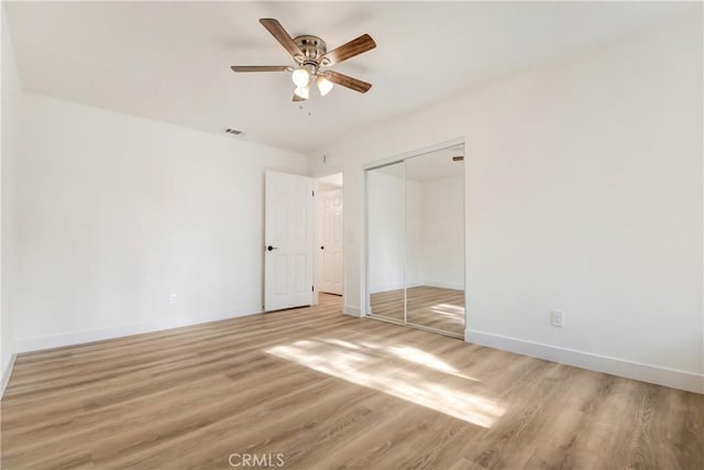 unfurnished bedroom with hardwood / wood-style flooring, a closet, and ceiling fan