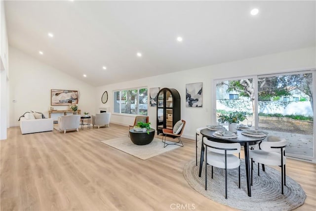 dining space featuring lofted ceiling and light hardwood / wood-style flooring