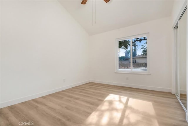 unfurnished bedroom with lofted ceiling, a closet, ceiling fan, and light wood-type flooring