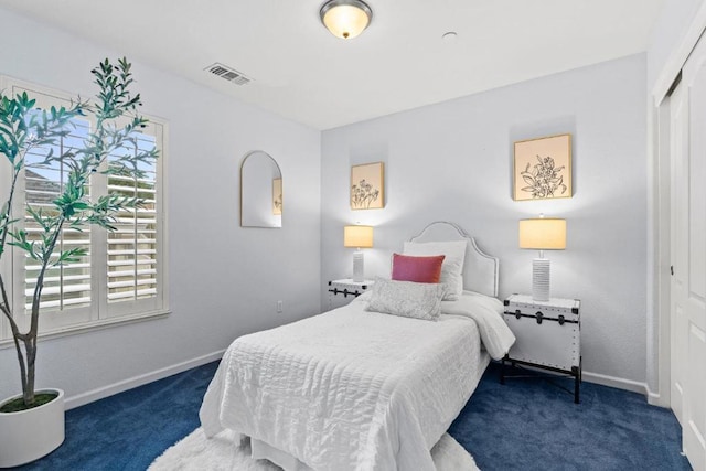 bedroom with dark carpet and a closet