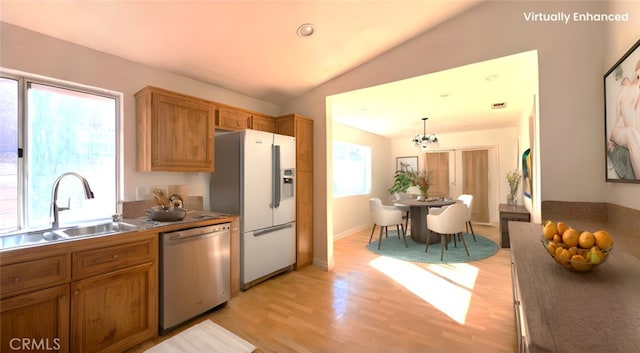 kitchen with sink, vaulted ceiling, hanging light fixtures, dishwasher, and white refrigerator with ice dispenser