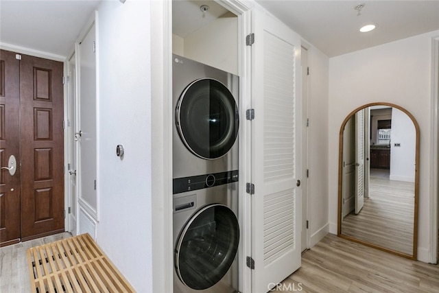 1023 Wilcox Ave Unit 102, Los Angeles, CA 90038 - washroom with estacked washer and dryer, arched walkways, light wood-style flooring, and recessed lighting