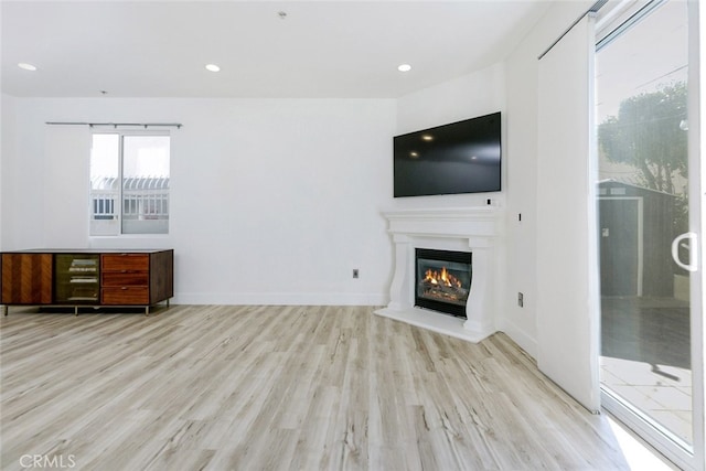 1023 Wilcox Ave Unit 102, Los Angeles, CA 90038 - unfurnished living room with a glass covered fireplace, wood finished floors, and recessed lighting