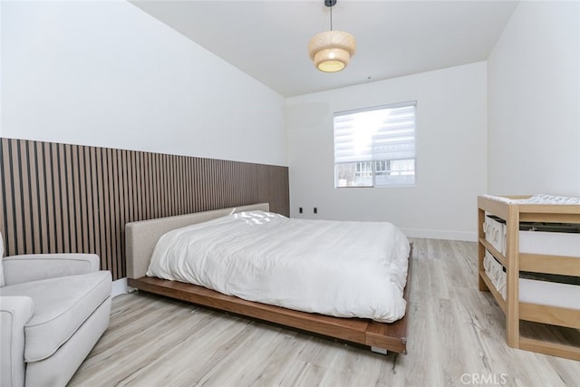 bedroom featuring lofted ceiling and light hardwood / wood-style floors