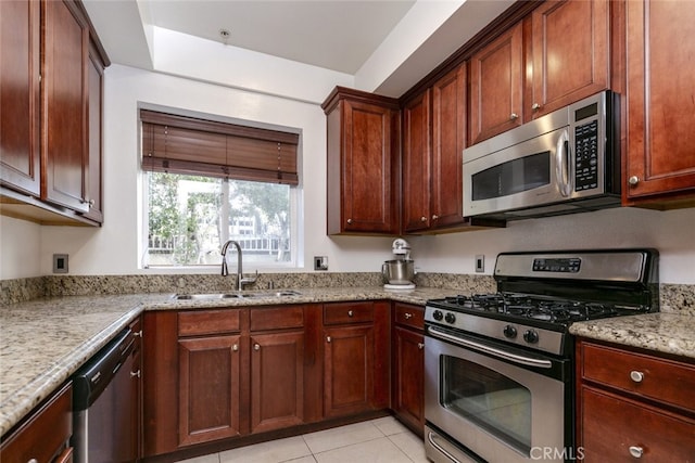 kitchen featuring sink, light tile patterned flooring, light stone countertops, and appliances with stainless steel finishes