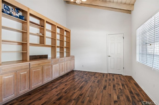 unfurnished living room featuring high vaulted ceiling, dark wood-type flooring, and beam ceiling