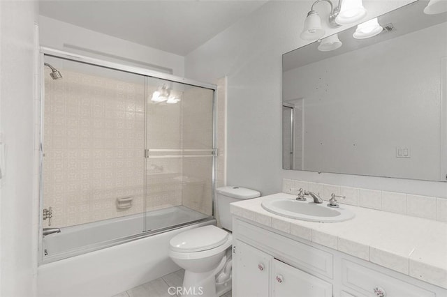 full bathroom with vanity, combined bath / shower with glass door, tile patterned floors, and toilet