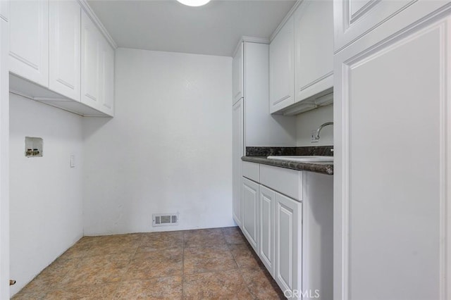 clothes washing area featuring cabinets, hookup for a washing machine, and sink