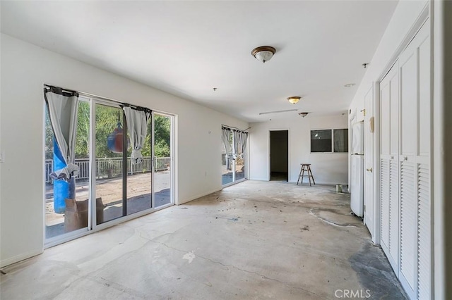 unfurnished living room featuring concrete flooring