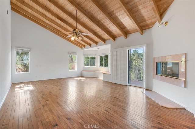 unfurnished living room with hardwood / wood-style flooring, high vaulted ceiling, and beam ceiling