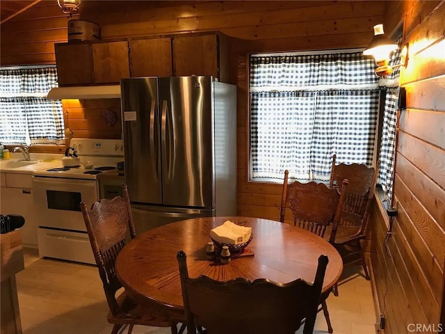 dining room featuring sink and wooden walls