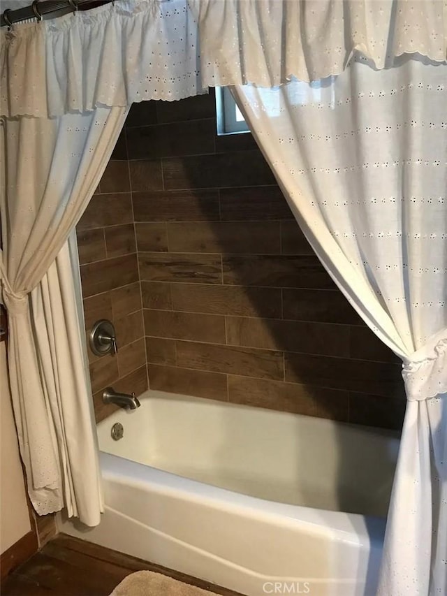 bathroom featuring shower / tub combo and wood-type flooring