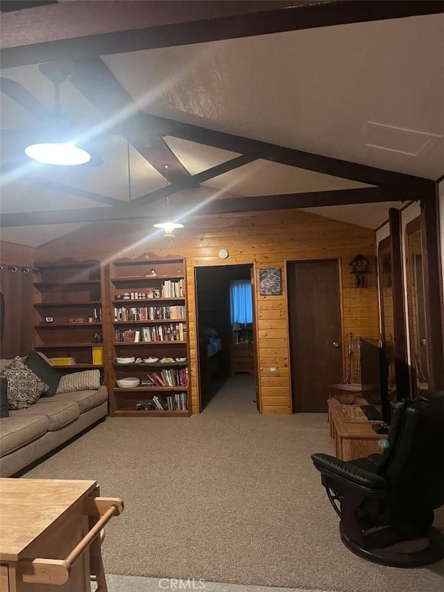 carpeted living room with vaulted ceiling with beams and wood walls