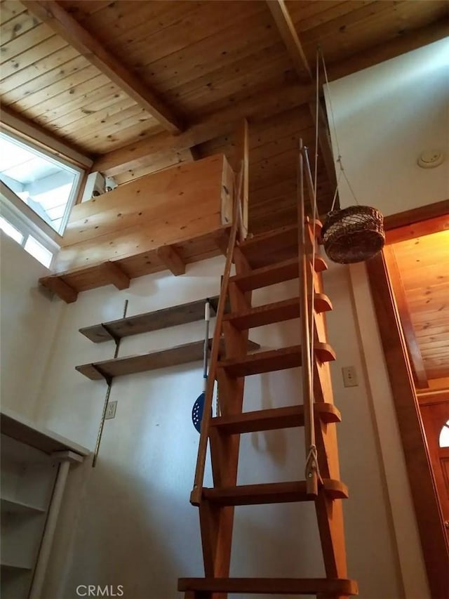 staircase featuring wood ceiling and beamed ceiling