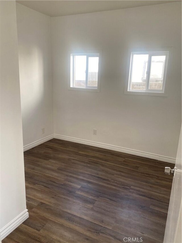 empty room with dark hardwood / wood-style flooring