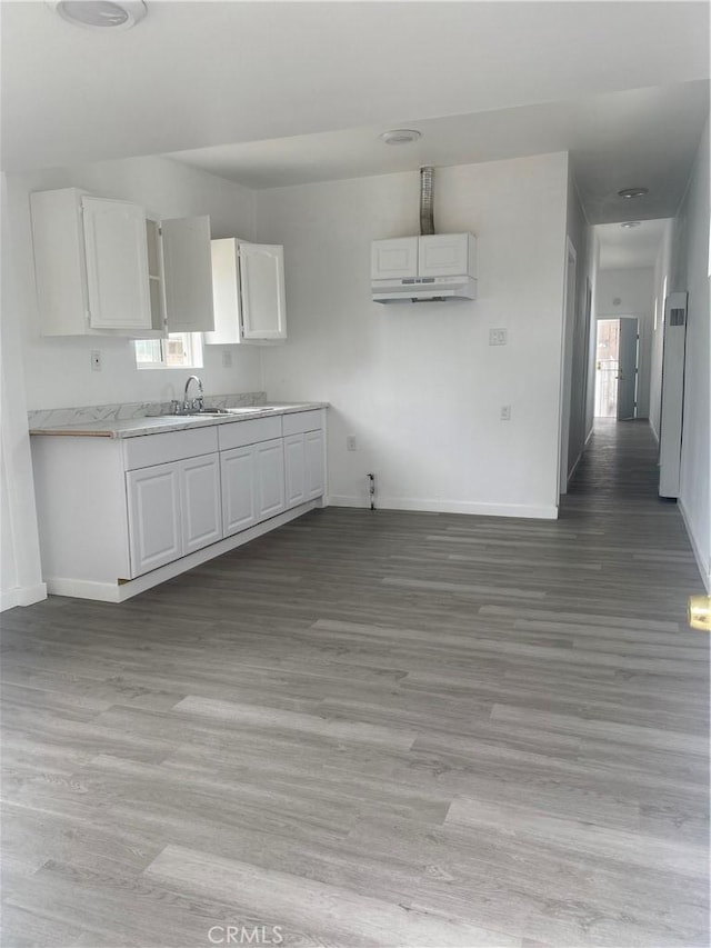 kitchen featuring sink, light hardwood / wood-style floors, and white cabinets