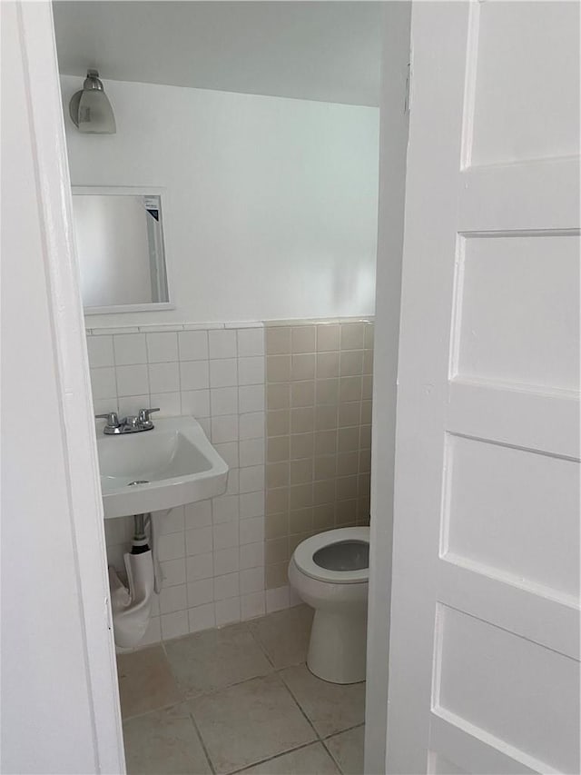 bathroom featuring tile walls, sink, tile patterned flooring, and toilet