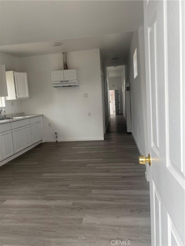 interior space with sink, hardwood / wood-style floors, and a wall unit AC