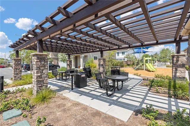 view of property's community with a playground, a patio, and a pergola