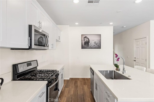 kitchen featuring white cabinetry, appliances with stainless steel finishes, sink, and a kitchen island with sink